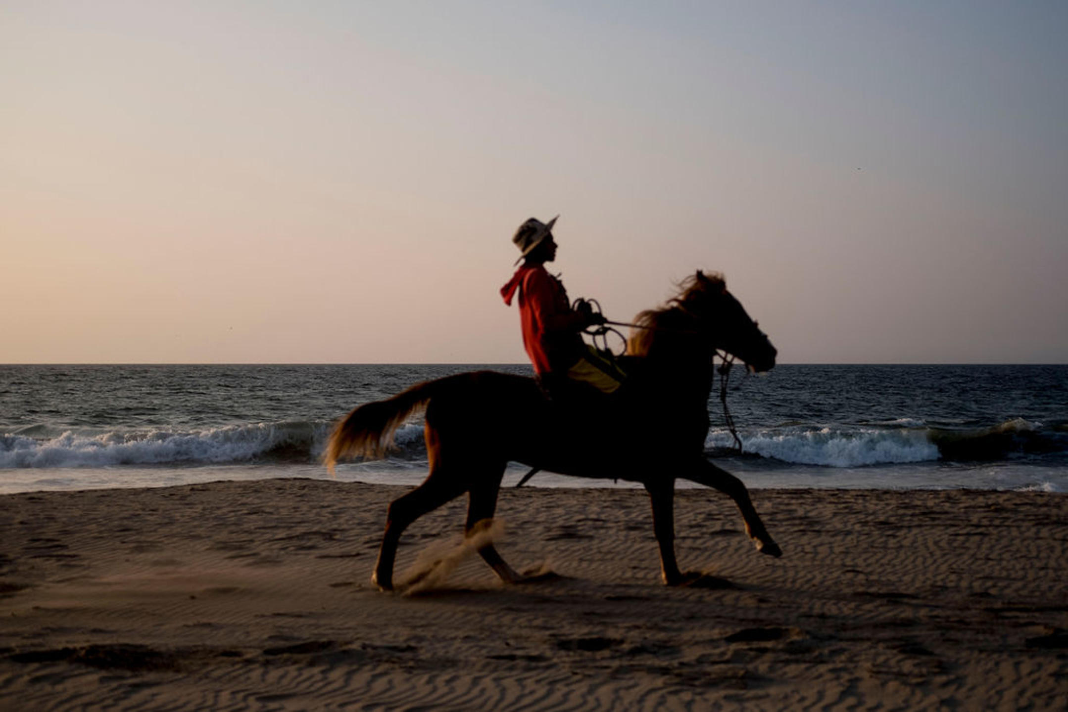 Paseo a caballo por la playa al atardecer